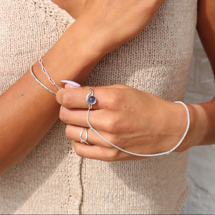 model wearing sterling silver hand chain with other sterling silver jewelry