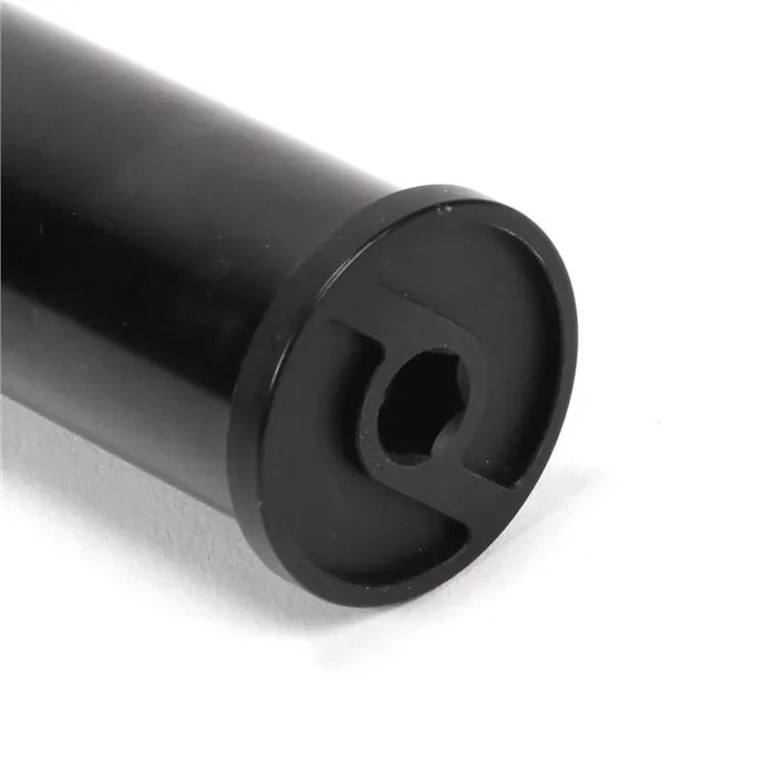 Close-up of a black cylindrical metal rod, identified as a Primo Balance Fork, featuring a hexagonal hole and two opposing slots at one end. The fork is crafted from heat-treated chromoly and is shown resting on a white surface.