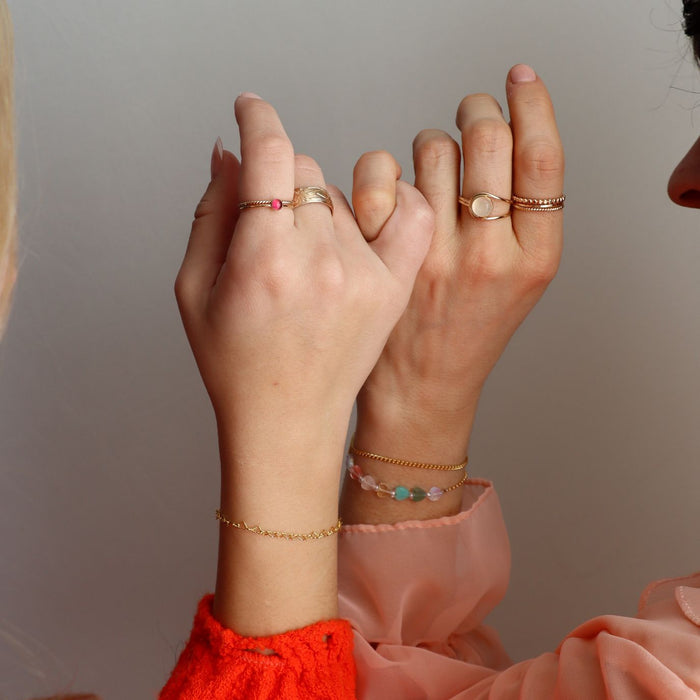 models wearing 14k gold fill rings with ruby and moonstone accents