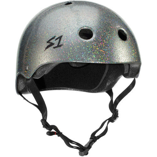 The S-One Helmet Mega Lifer in Silver Glitter features a sparkly matte silver finish, ventilation holes, black chin straps, and an "S1" logo on the front left side. This certified skate helmet provides multiple impact protection for your safety.