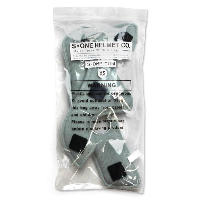 A clear plastic bag containing XS-sized S-One Helmet Wide Terry Cloth Liners, designed as washable sweat-absorbing replacements for helmet sizing. The bag has warning labels to keep out of reach of babies and children due to potential suffocation hazards.