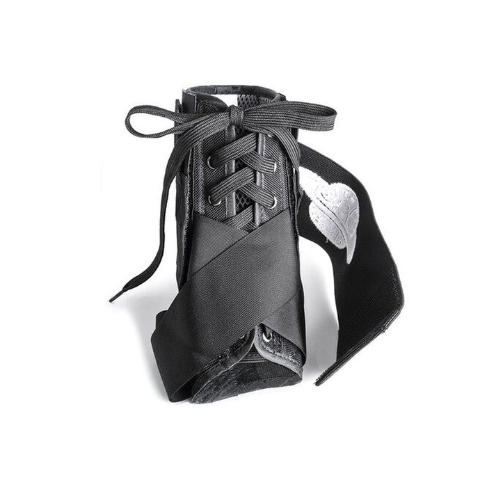 The Space Brace Ankle Brace V1 is a black shoe inspired by pointe ballet shoes and sneakers, featuring ribbon laces, a white embroidered leaf on one side, and discreet ankle support for enhanced comfort.