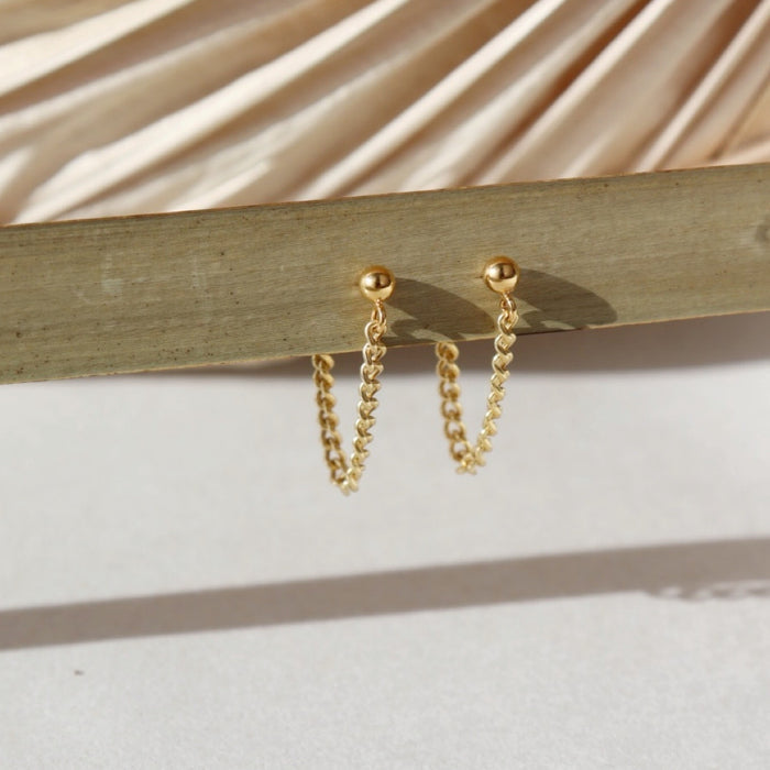 14k gold fill small curb chain stud earrings hanging in the sunlight