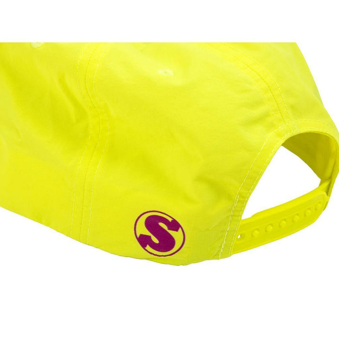 A close-up of the back of a bright yellow Sunday High Wave Cap, showcasing a purple "S" logo near the adjustable strap—ideal for Back to School 2025.
