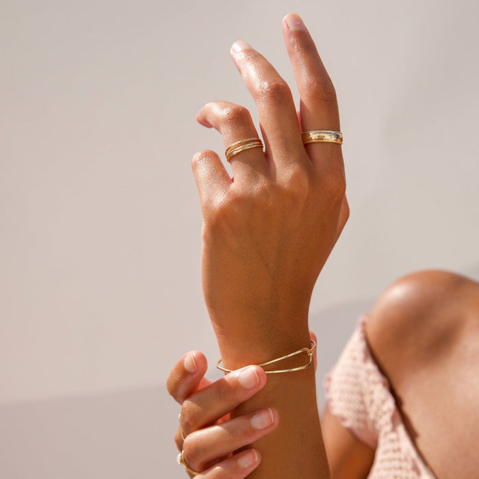 model wearing 14k gold fill wire bracelet in the sunlight