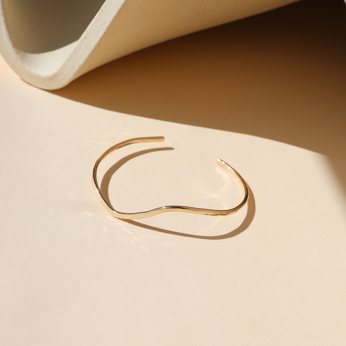 14k Gold Fill Swell Cuff Bracelet featuring a sculptural organic wave design, minimalist open cuff bracelet displayed in warm natural light.