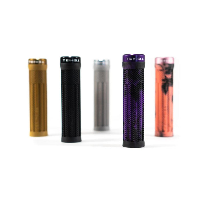 Five Tenet Components Icon Grip mountain bike grips in gold, black, gray, purple, and pink—each featuring extra soft textured rubber—stand upright on a white background.
