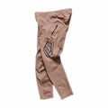 The TLD 26.1 Sprint Pro Pants / Mono Sienna are light brown athletic pants with a black thigh logo, zippered pocket, visible seams, and made from 4-way stretch fabric, shown laid flat on a white background.