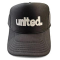 The United Coastin Trucker Hat is a black hat featuring "united." printed in bold white letters on the front.