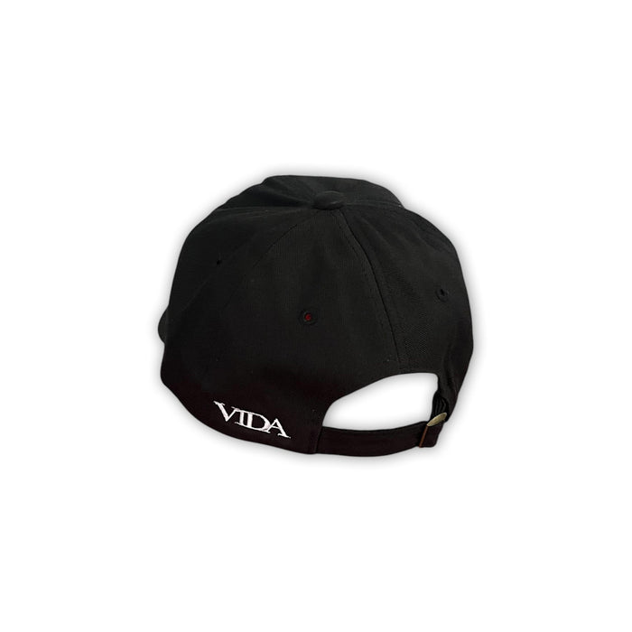 V1da The Dad Cap, shown from the back, features "VIDA" embroidered in white above the adjustable strap. This unstructured black hat offers a classic, low-profile fit.