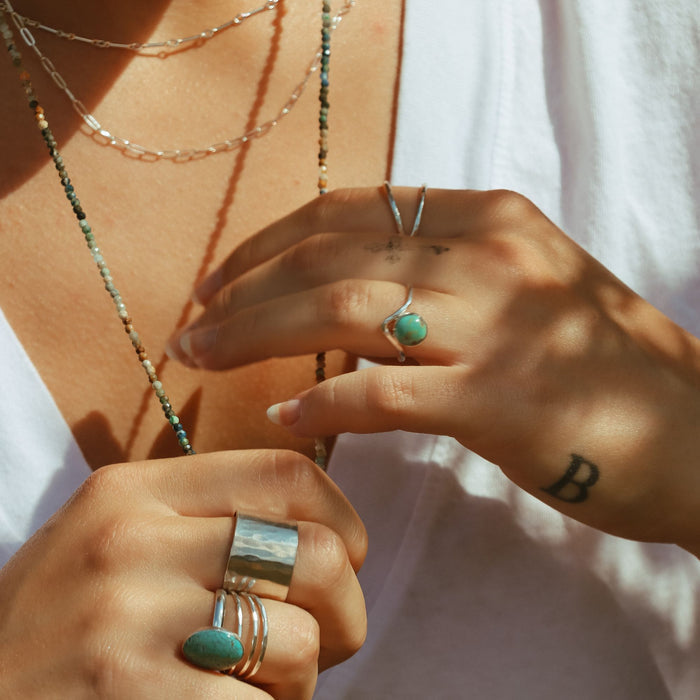 model wearing sterling silver rings with turquoise accents