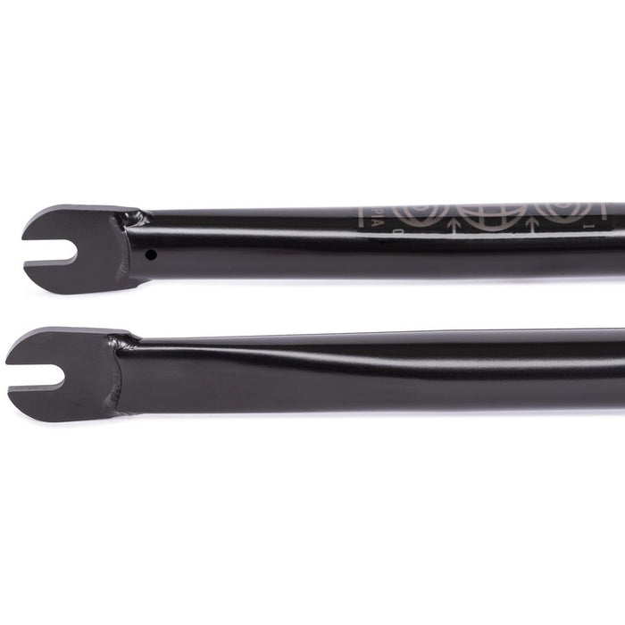 The Wethepeople Utopia Zero Flatland Fork, a pair of black metal bicycle forks with zero-offset dropouts, rests against a white background, ideal for BMX flatland riders wanting precision and style.