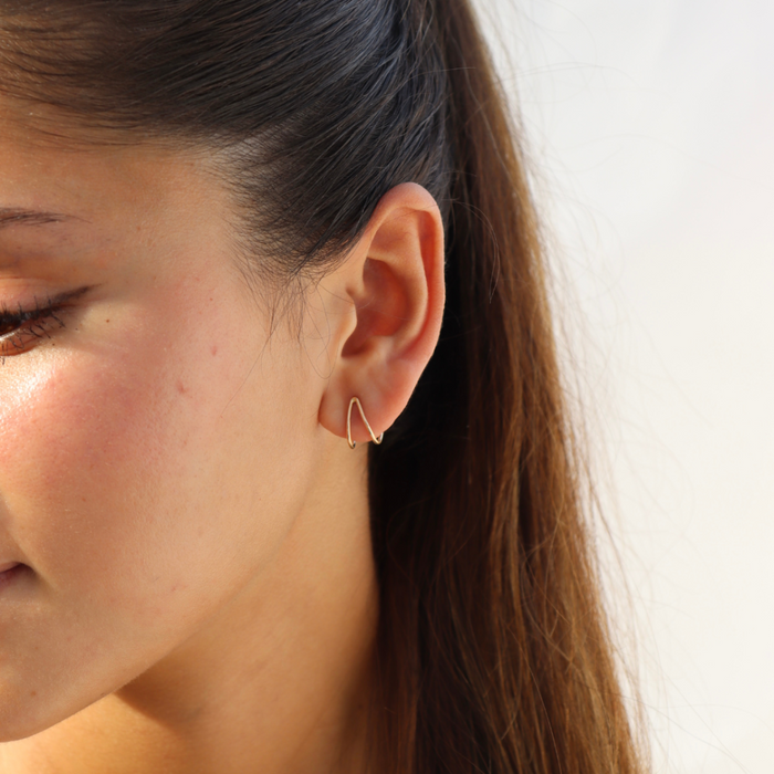 model wearing 14k gold fill wishbone style stud earrings