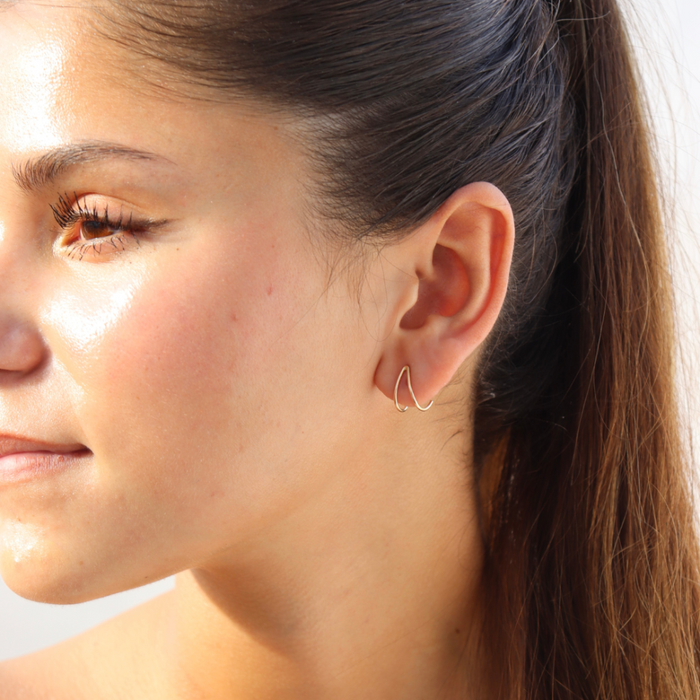 model wearing 14k gold fill wishbone style stud earrings